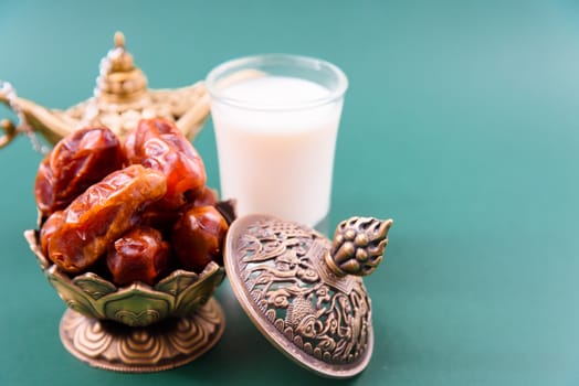 Ramadan, Dates in golden bowl, Milk, arabian Aladdin golden lamp vintage style on black green background
