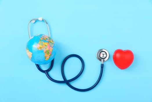 World health day concept, Stethoscope, globe and red heart on blue background with copy space. Global health care