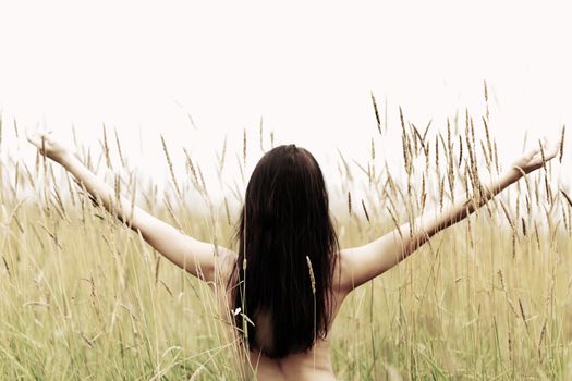 woman on grass field feel freedom standing with arms raised