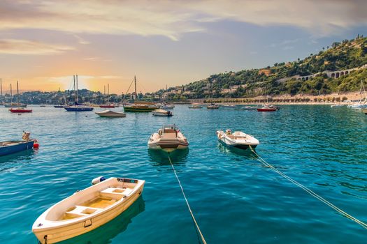 Small Fishing boats moored and anchored in a calm blue bay