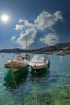 Two small boats moored in shallow water of a harbor