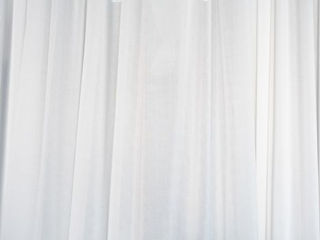 The white curtain is made of muslin fabric with soft sunlight in the morning passing through.