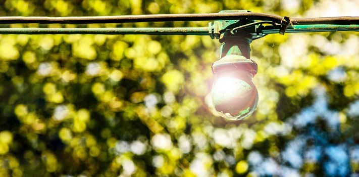 green painted light out in country side with bulb glowing