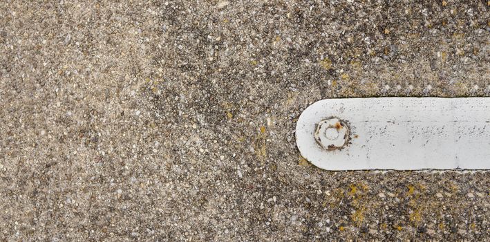 cement floor with hook and bolted down iron fixture with banner space for copy