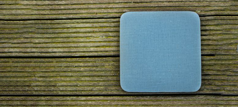 wood background with a blue seat pillow with copy space