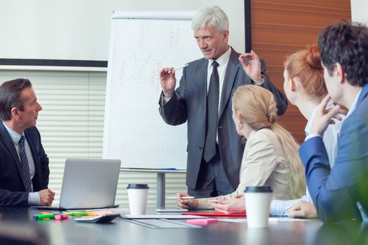 Business man speaking on seminar , whiteboard or flipchart on background