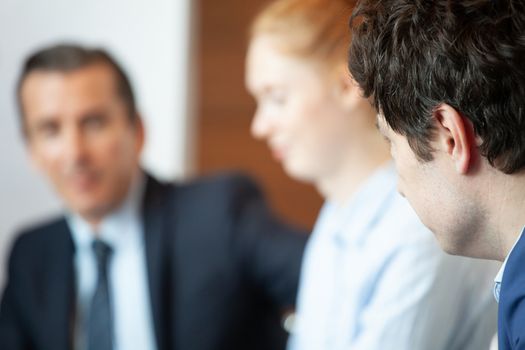 Business people sitting in a row and working, abstract defocused background