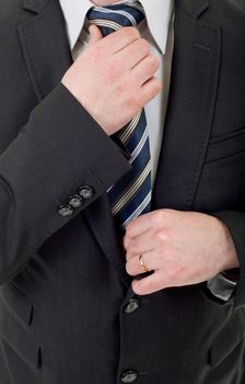 businessman in black suit adjusting tie