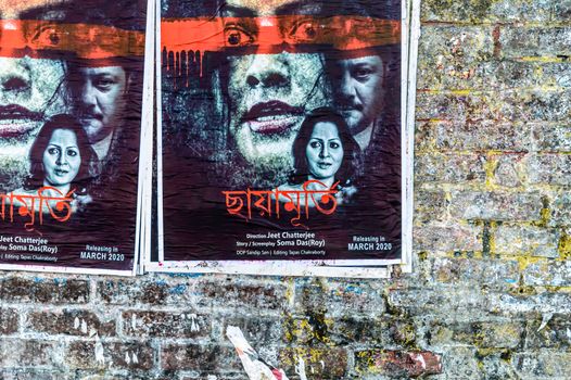 Bengali Tollywood Indian movie posters on an old brick wall of city street. Tollygunge Kolkata West Bengal India South Asia Pacific March 2020