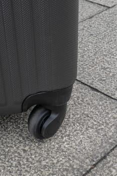 The close up of Wheeled luggage travel bag on concrete texture ground.