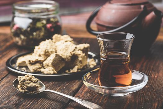 Black tea in armudu glass and spoonful of sunflower halva