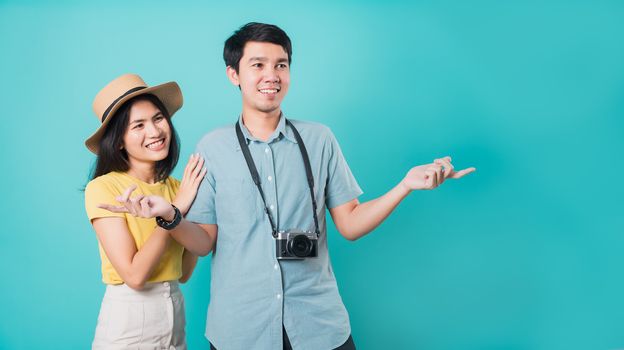Happy Asian couple young beautiful woman handsome man smiling white teeth with camera in surprise summer holiday travel tourists isolated on blue background with copy space for text