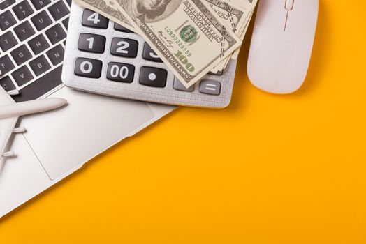April of the year is Tax Day, Top view flat lay closeup calculator, laptop computer and Dollar money, on yellow background business finance budget concept with copy space for text