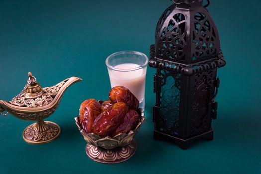 Ramadan Kareem fasting Food Concept, Bronze plate dates, milk, and lantern Aladdin lamp decoration, eid Arabian Muslim religious festival on a dark green background with copy space for text