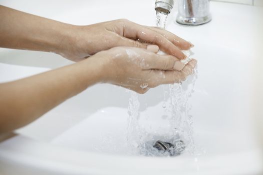 Woman washing hands with soap