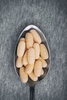 Medical pills on a metal spoon. Close-up photo