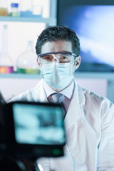 Laboratory hospital clinic doctor, scientist or exper, wearing protacive mask while addressing public in media interview explaining preventive measures against corona virus pandemic outbreak.