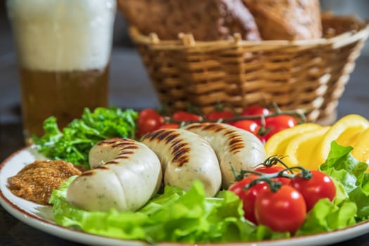 Appetizing grilled chicken sausages on a plate with herbs and vegetables