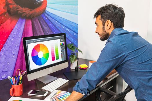 Concentrated young man working and standing in front of a computer