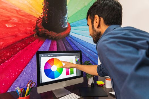 young bearded man pointing at computer. Business employee working serious and concentrated.