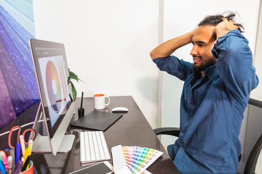 Male looking at his computer with hands on head showing frustrated angry emotion.