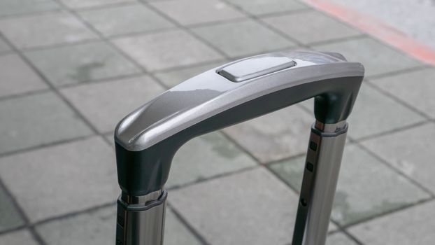 The close up of travel luggage handle on street at urban city.