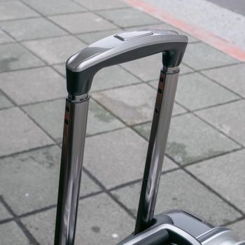 The close up of travel luggage handle on street at urban city.