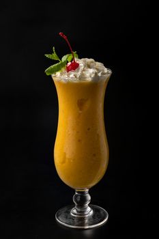 Alcoholic cocktail in a glass beaker on a plain black background