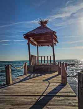 A beautiful straw hut in the sea lighted by the summer sun.