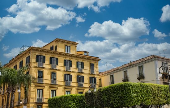 An old yellow hotel in Sorrento with black shutters