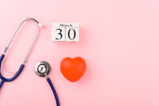 Doctor's Day concept, flat lay top view, equipment medical red heart and stethoscope on pink background, care patient in hospital with copy space for text