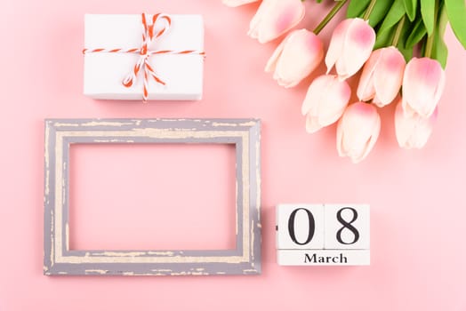 Happy Women's Day, Mother's Day concept. top view flat lay Tulip flower and photo frame on pink background, copy space for your text