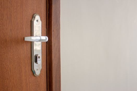 Door handle of a simple wooden door on the entrance of an apartment