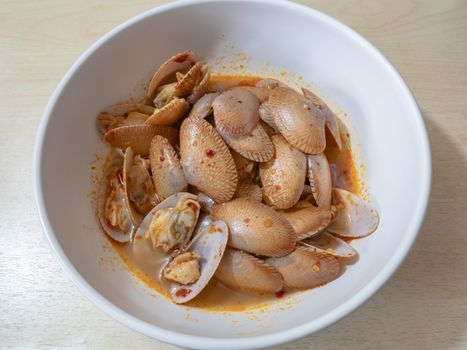 The close up of Thai Stir Fried Clams with Roasted Chili Paste on white bowl.