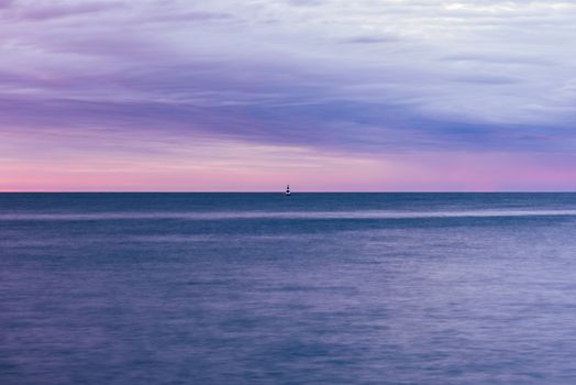 single black and white striped buoy on river at sunrise