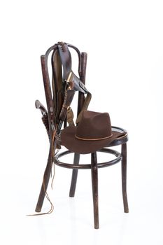 Cowboy belt, guns and hat on an old chair on isolated background