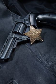 Star badge and revolver on a studio background
