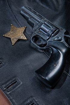 Star badge and revolver on a studio background
