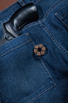 Revolver and jeans on a studio background