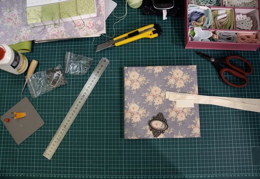the process of handmade creating of the diary from special scrapbooking paper, paper flowers and other decorative elements