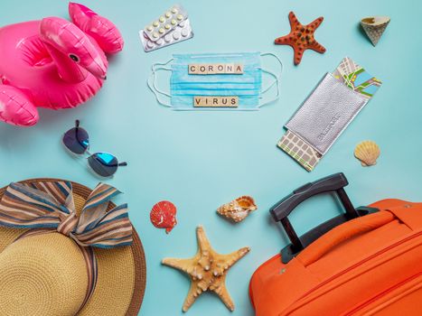 Coronavirus covid-19 and travel concept. Summer vacation and beach rest symbols and breathing mask on blue background. Flat lay or top view. Copy space for text or design.