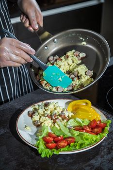 Omelet with herbs and vegetables on a gray table in the kitchen