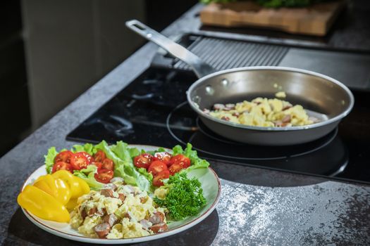 Omelet with herbs and vegetables on a gray table in the kitchen