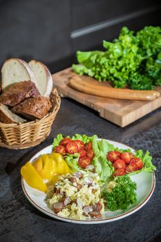 Omelet with herbs and vegetables on a gray table in the kitchen