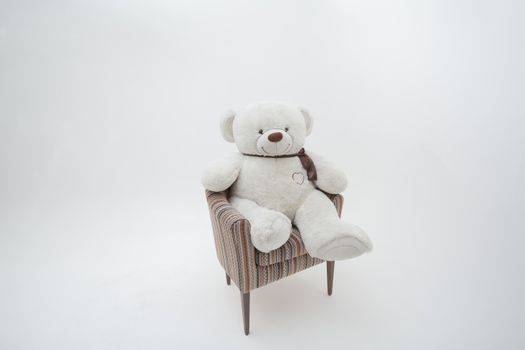 Teddy bear and classic soft chair on white blackground