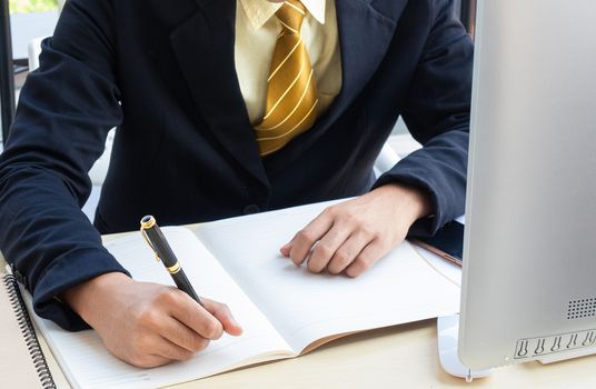 The executive is sitting on the desk, taking note of the creative ideas for the organization's direction in the modern office.