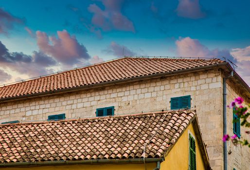 Two old stone buildings in Kotor, Montenegro with clay pipe roofs