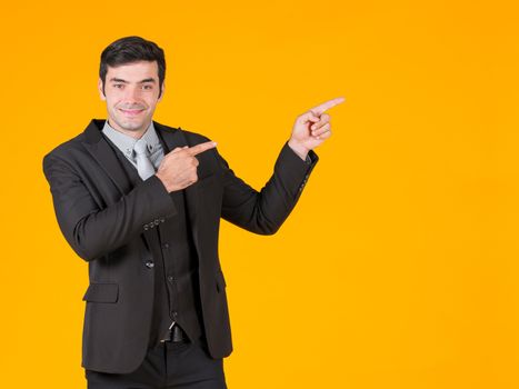 A young businessman in a gray shirt and a black suit pointing both finger in the same direction. Shows the project that is currently soaring. The concept of investing in a successful business.