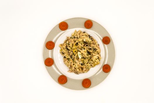 Plate of chicken hen with carrot slices on a white background