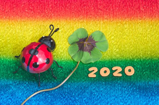The picture shows lucky clover and a ladybird on colorful crepe paper